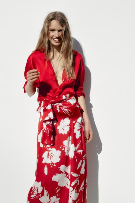 Zara estiliza la prenda con una falda midi en rojo satinado y estampada con flores blancas
