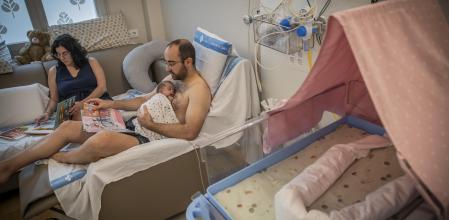 06 - 08 - 2024 / Barcelona / Biblioteca UCI neonatos Vall Hebron - Chloe niña que sus padres le leen libros / Foto: Llibert Teixidó. Biblioteca en la uci de neonatos para estimular el neurodesarrollo de los bebés. El Vall d’Hebron fomenta la lectura en voz alta de los padres a los prematuros. Miquel Cortés le lee un cuento a Chloe, que nació a las 29 semanas, en presencia de su madre, Bea.